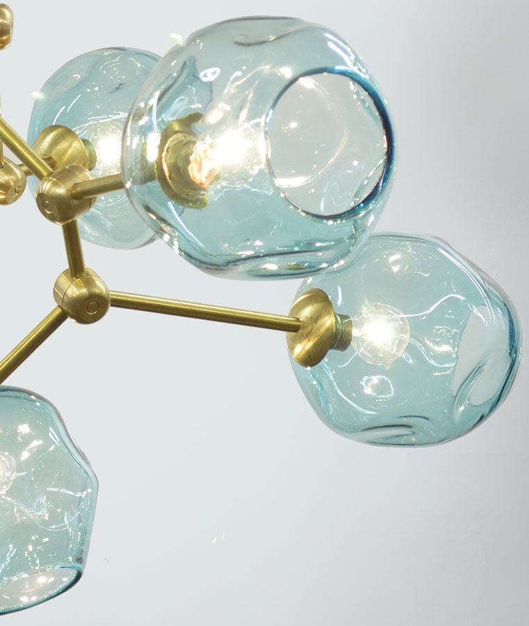 Close-up of Petra Corinne chandelier featuring handblown glass luminaires and brass hardware.