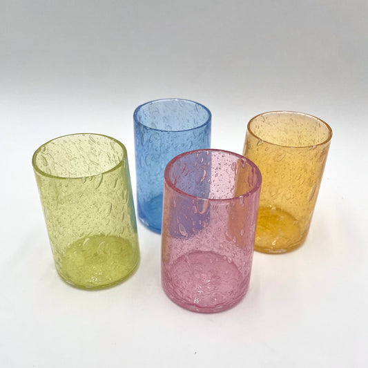 Four colorful textured glass tumblers on a white background