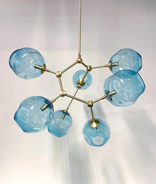 Petra Corinne Chandelier with handblown blue glass globes and gold hardware, showcasing stunning craftsmanship and design.